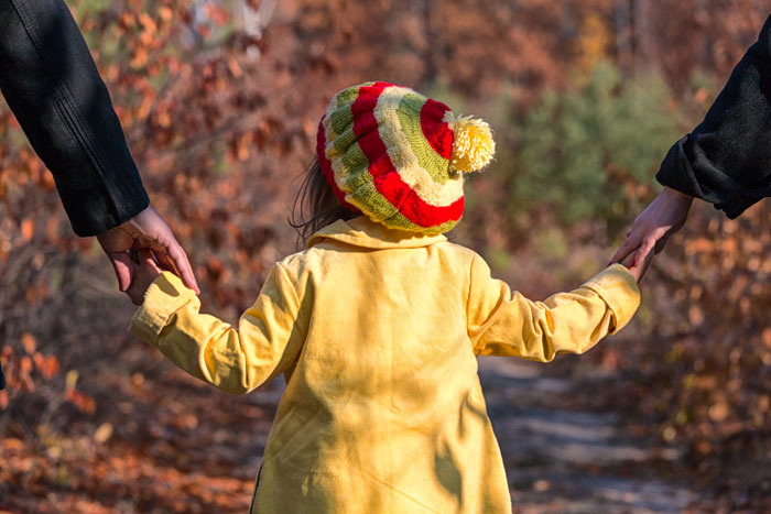 Parents holding the hands of a child, who is always put first in the collaborative law process, created to give people who need a divorce lawyer a low cost way to obtain a no contest divorce, an uncontested divorce or out of court divorce in Alberta.